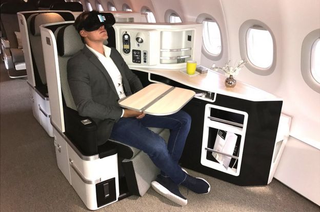 Man wearing VR headset in first class air cabin
