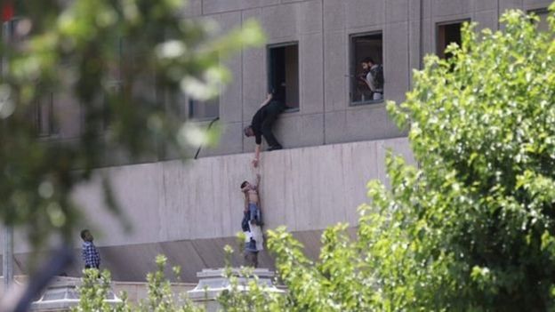 Hình ảnh này cho thấy một trẻ em đang được đưa ra khỏi nhà quốc hội Iran qua cửa sổ.