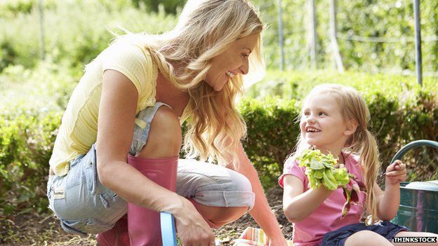 Mother and daughter smiling while gardening