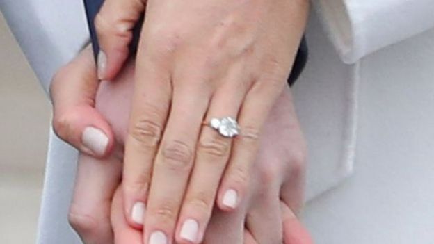 马克尔还向记者显示她戴的钻石订婚戒指。