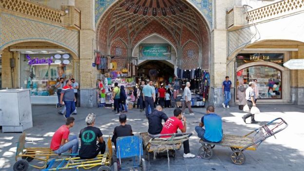 Iranians wait outside Tehran's ancient Grand Bazaar in Tehran on 28 July 2018