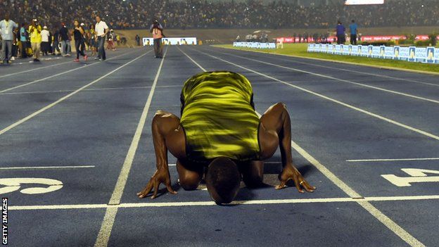 Usain Bolt kisses the track after running his last race on home soil in Jamaica