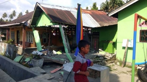 A boy walking in front of a collapsed house after a 6.1 magnitude earthquake that hit in Donggala, Central Sulawesi, Indonesia, 28 September 2018.