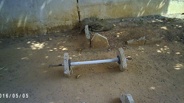Makeshift weight bar made from metal and stone