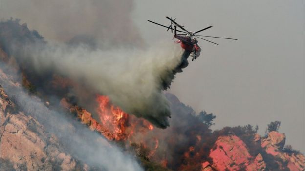 Một chiếc trực thăng thả hóa chất làm giảm tốc độ cháy lan của lửa hôm 10/11