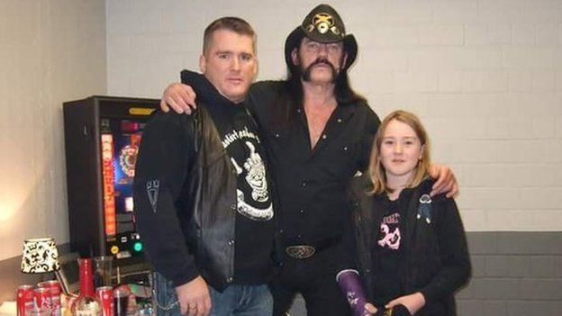 Lemmy poses with Mr Hahn and his daughter, with her arm in plaster (which he signed)