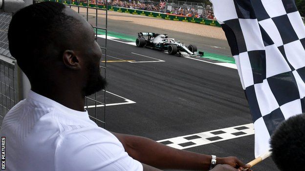 Stormzy waves the chequered Flag