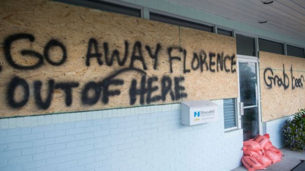 a sign tells the hurricane to "go away"