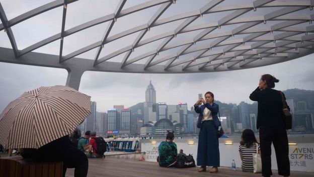Khách du lịch chụp ảnh Cảng Victoria ở Hong Kong.