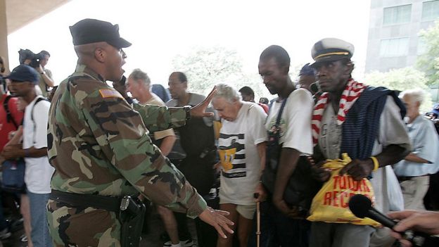 Un soldado intenta poner orden en la fila de acceso al estadio Superdome de Nueva Orleans.