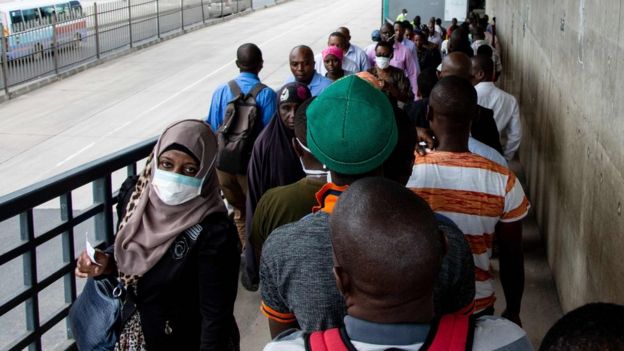 People walk on a pedestrian bridge in Dar es Salaam, Tanzania - 16 April 2020