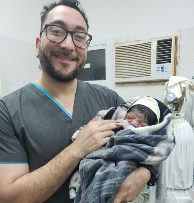 Daniel Gatica con un bebé recién nacido