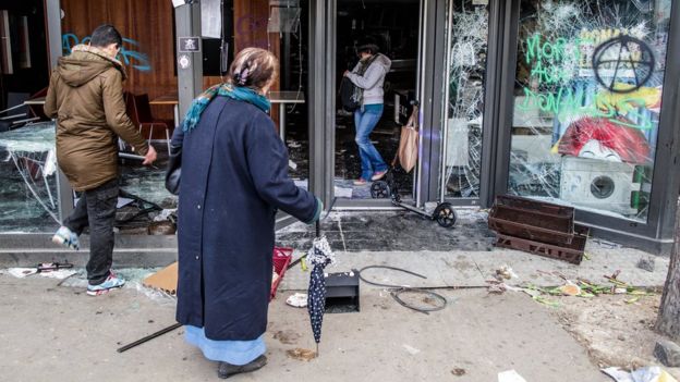 Pedestrians look at a destroyed McDonald's fast food restaurant after a demonstration of workers from the private and public sectors as well as labour unions on the occasion of the annual May Day