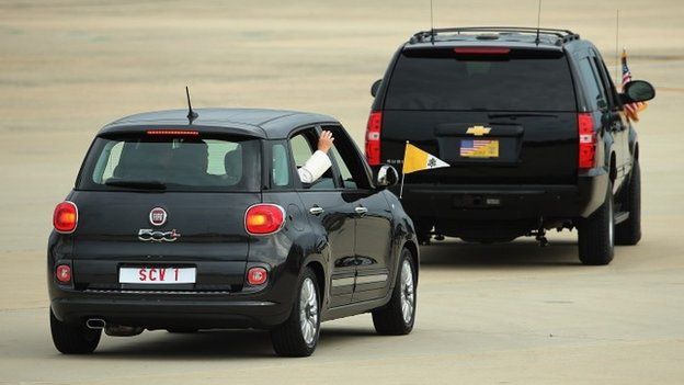 Pope Francis waves from the back of his Fiat