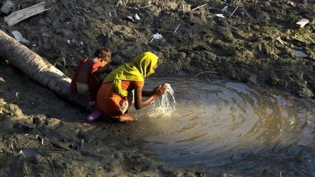 Dos niños recogen agua en un pozo