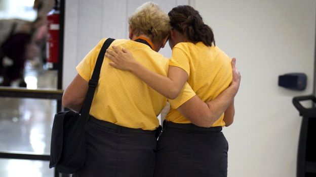 Two Thomas Cook staff members hug at Son Sant Joan airport in Palma de Majorca, 24 September 2019