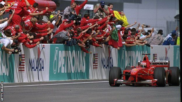 Eddie Irvine crosses the finish line to take victory at the inaugural Malaysian Grand Prix