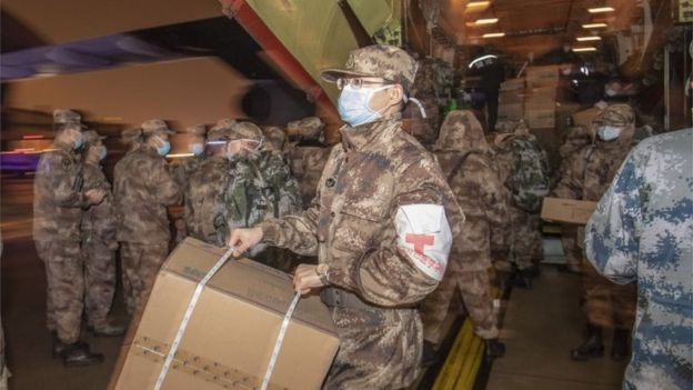 Médicos militares bajan suministros de un gran avión en Wuhan
