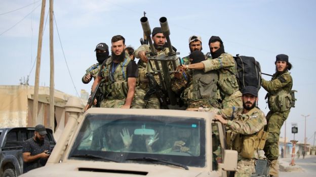 Soldados sírios avançam em veículo militar armado