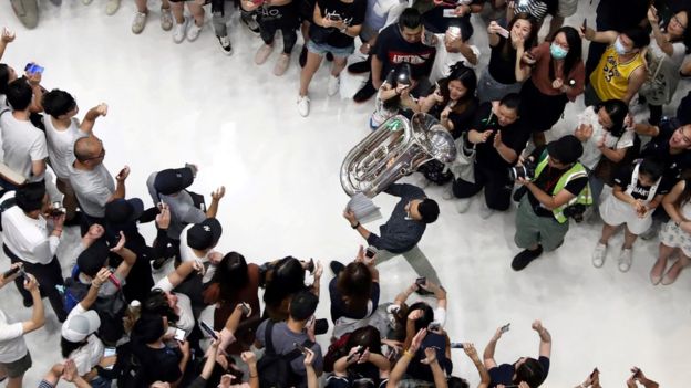 香港多个商场有示威者聚集唱《愿荣光归香港》。