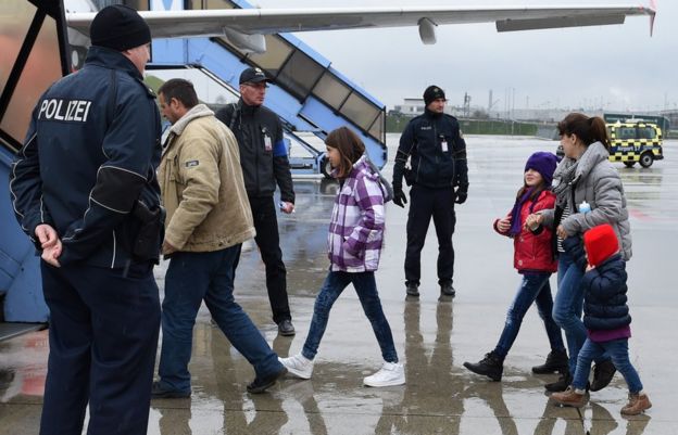 Police officers escort rejected asylum seekers to a plane at Franz-Josef-Strauss airport in Munich, southern Germany, on December 9, 2015