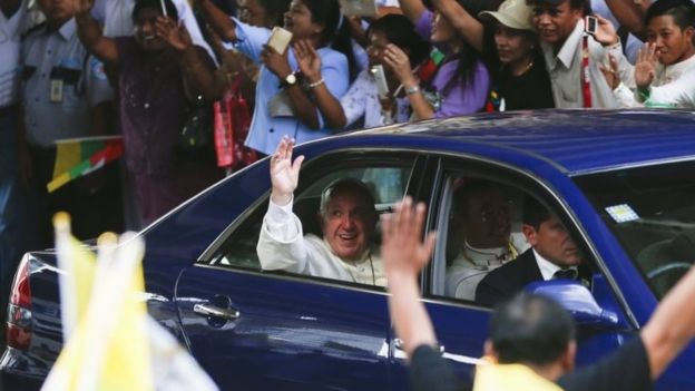 Pope Francis (C) waves from inside a vehicle as as he is welcomed by the crowd along a road in Yangon, Myanmar, 27 November 2017.