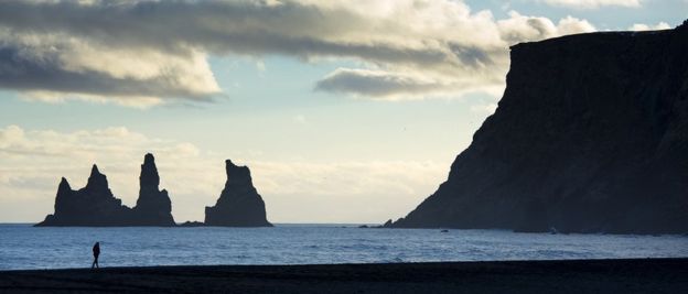 Turis di pantai Reynisfjara dekat desa Vík i Myrdal, Islandia Selatan