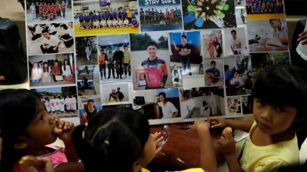 Children looks at photos of the trapped boys at a church in Chiang Rai