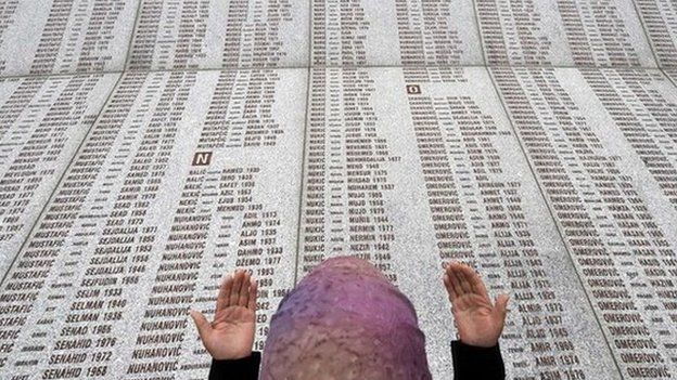 In this 2008 picture, a Bosnian Muslim woman prays at the memorial wall with the names of the victims of the Srebrenica massacre
