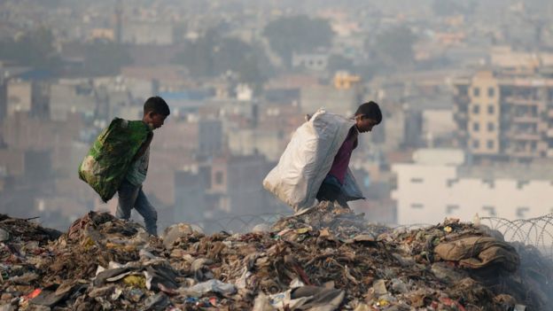 Crianças recolhem materiais em lixão de Nova Déli, na Índia