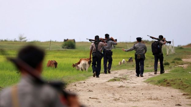 In this photo taken on September 7, 2017, armed Myanmar police patrol fields near Maungdaw in the northern Rakhine state in northern Myanmar