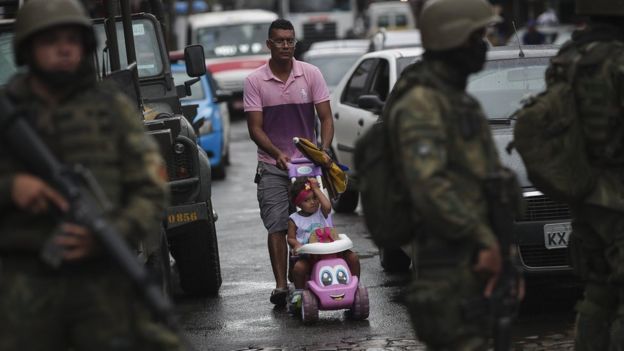 Homem caminha com criança no Rio