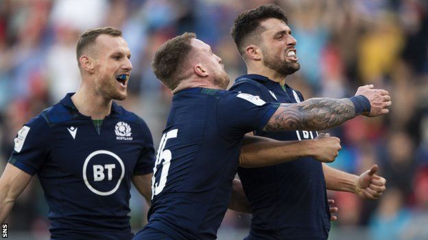 Adam Hastings celebrates scoring a try for Scotland against Italy in Rome