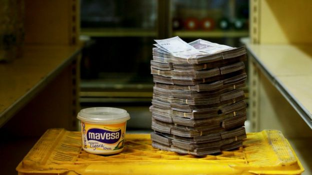 A tub of margarine is pictured next to a stack of 3 million bolivars - equivalent to 46 US cents at a market in Caracas on 16 August