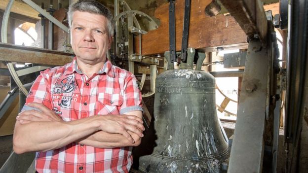 Now former mayor Ronald Becker stands next to the church bell embossed with a swastika and the text: 'Everything for the Fatherland Adolf Hitler' in the Jakobskirche village church on June 13, 2017 in Herxheim, Germany.