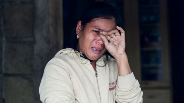 A woman cries recounting her experience during typhoon