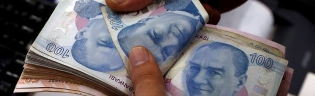 A man counts Turkish lira banknotes