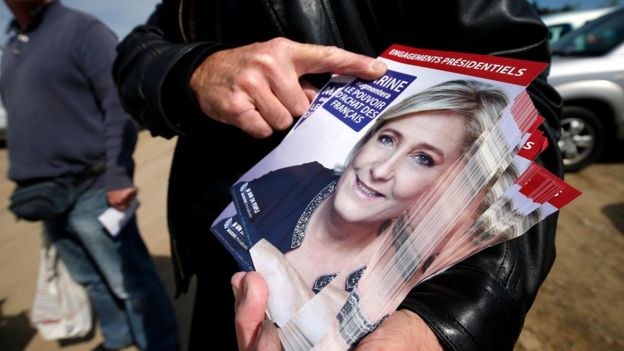 A supporter of Marine Le Pen distributes flyers of French presidential election candidate for far-right Front National (FN) party, Marine Le Pen in Valbonne, southern France, 30 April 2017.