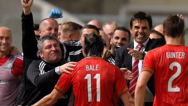 Gareth Bale celebrates with Wales' coaches