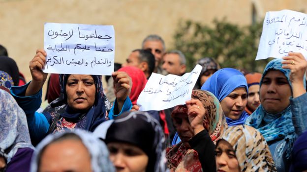 Mujeres y hombres palestinos en una protesta en Líbano por la falta de ayuda