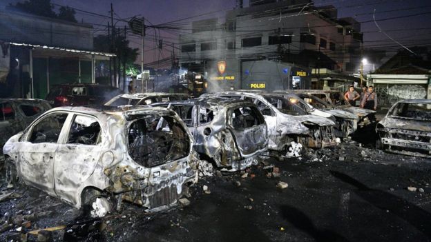 Police officers inspect the damage after cars were set on fire at Brimon (Mobile Police) Dormitory Complex