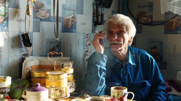 Vladimir Voskresenskiy sitting, smoking a cigarette