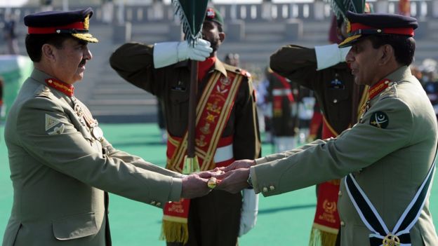 Pakistan's outgoing army chief General Ashfaq Kayani (R) presents the change of command baton to newly-appointed army chief General Raheel Sharif (L) during the change of command ceremony in Rawalpindi on November 29, 2013
