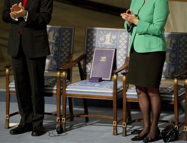 The Nobel Peace Prize committee Chairman Thorbjoern Jagland (L) and Kaci Kullmann Five (R) applaud as they stand next to the empty chair of the laureate holding his award at the ceremony for the Nobel Laureate and dissident Liu Xiaobo at the city hall in Oslo on December 10, 2010.
