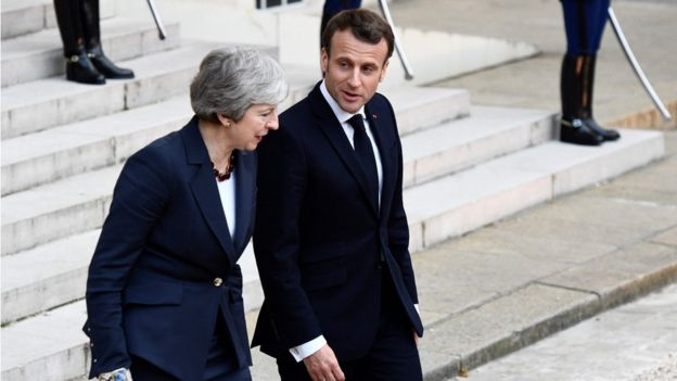 French President Emmanuel Macron (R) accompanies out British Prime Minister Theresa May after a meeting at the Elysee Palace in Paris on Tuesday