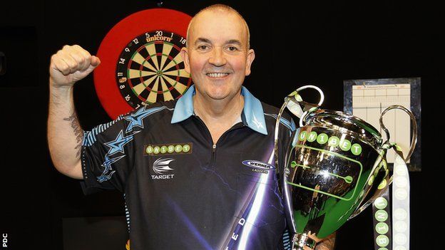 Phil Taylor celebrates after winning the inaugural Champions League of Darts