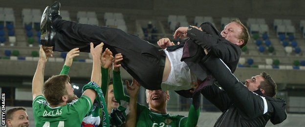 Northern Ireland manager Michael O'Neill is thrown in to the air by players