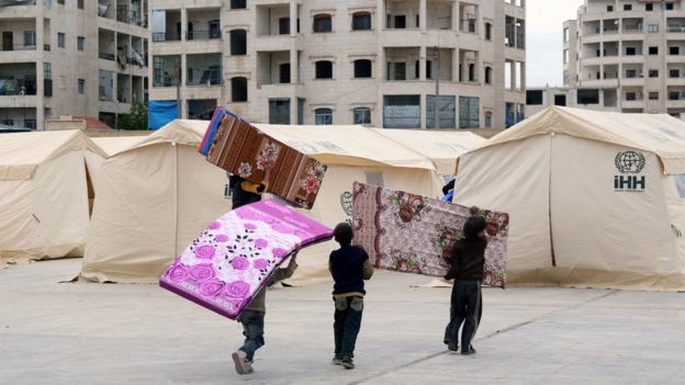 Niños sirios preparan las tiendas que acomodarán los civiles evacuados.