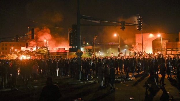 Les manifestants se rassemblent devant le poste de police en feu du 3e district de Minneapolis le 28 mai 2020