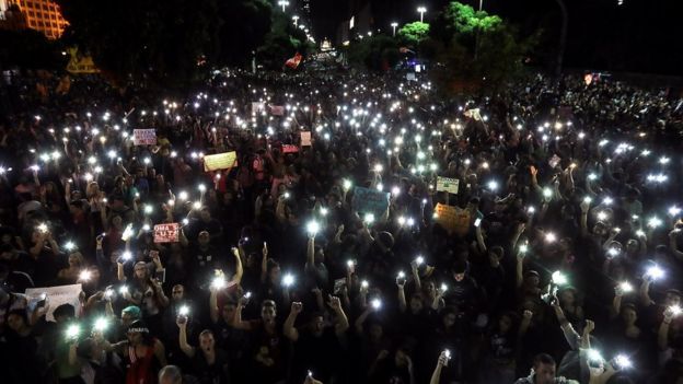 Centenas de manifestantes levantam celulares iluminados em grande avenida do Rio de Janeiro